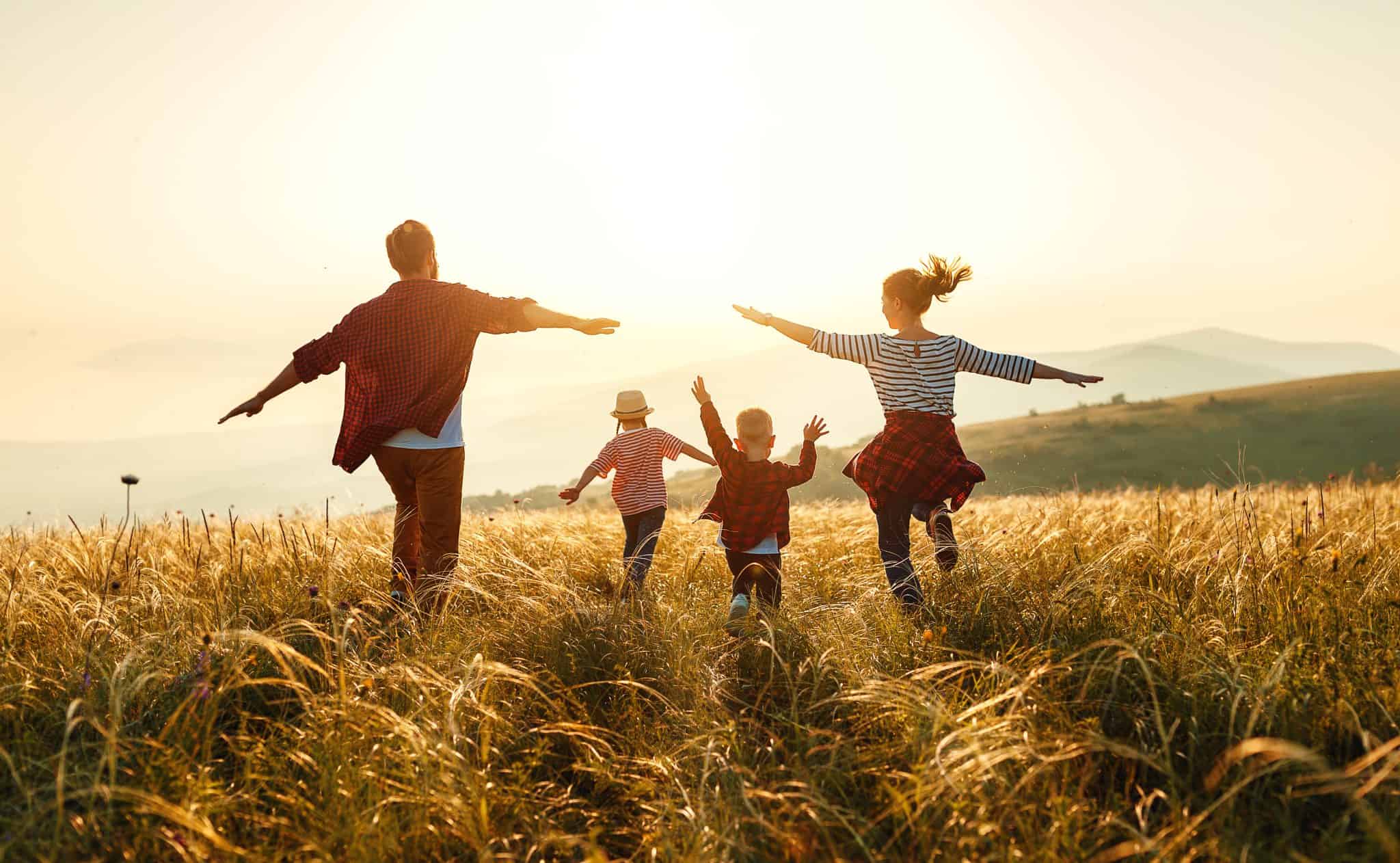 famiglia che corre felice in un campo di grano